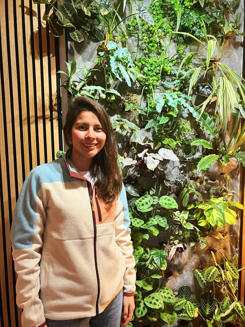 Catalina voor haar verticale tuin vol groene planten
